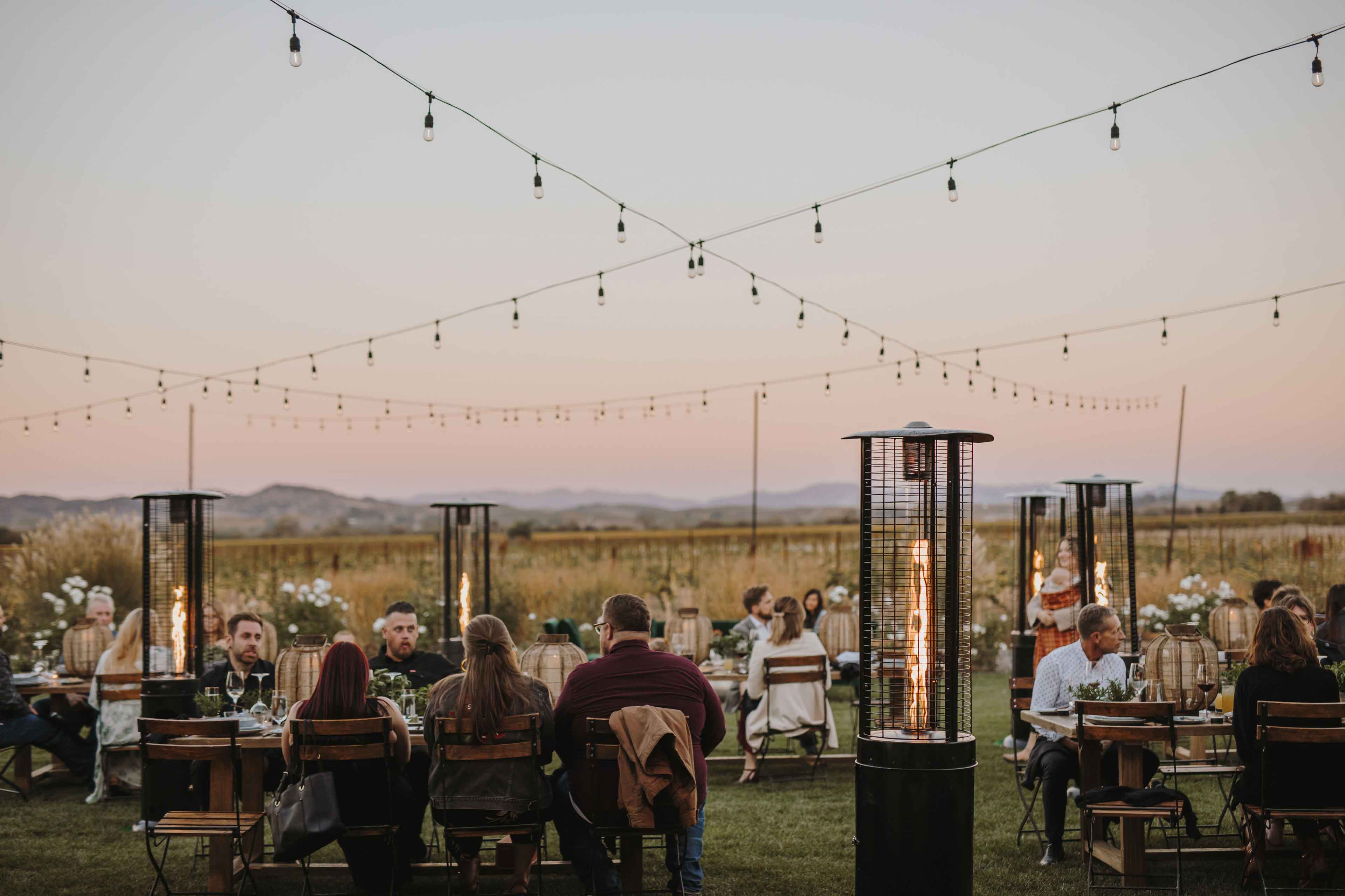 Guests sitting at tables at outdoor evening event